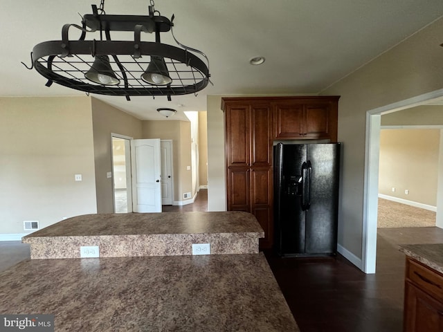 kitchen featuring dark hardwood / wood-style floors and black fridge