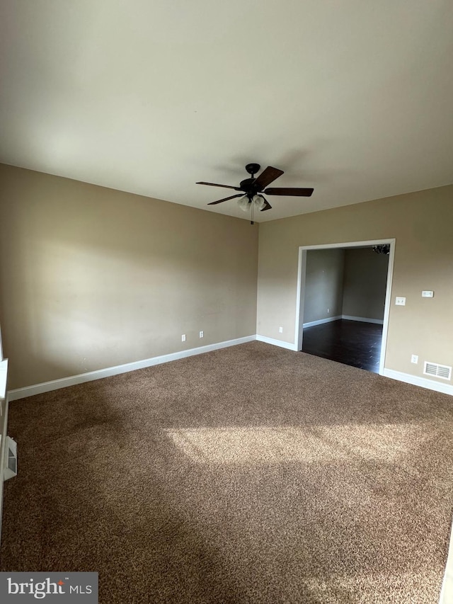 spare room with dark carpet and ceiling fan