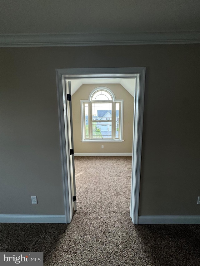 corridor featuring carpet, lofted ceiling, and ornamental molding