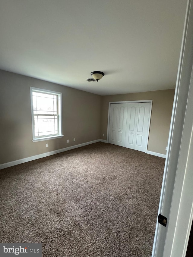 unfurnished bedroom featuring a closet and carpet