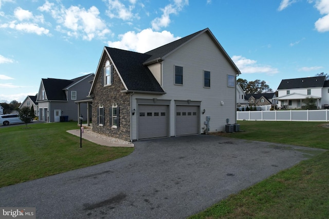 view of side of home featuring a yard, cooling unit, and a garage