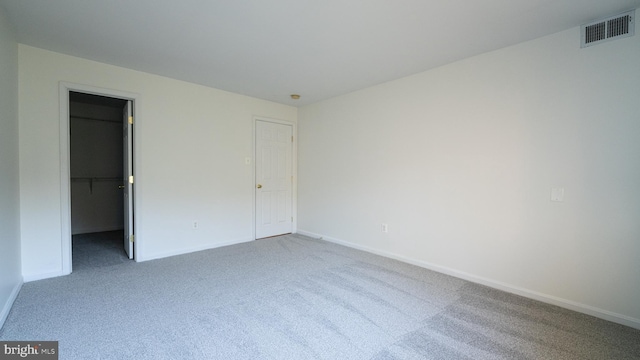 unfurnished bedroom featuring carpet floors and a spacious closet