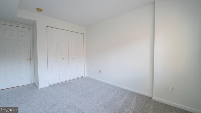 unfurnished bedroom with carpet flooring and a closet