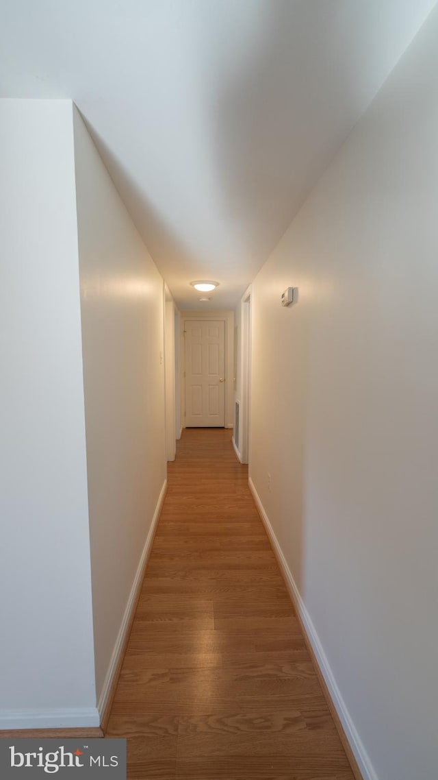 hall with hardwood / wood-style floors