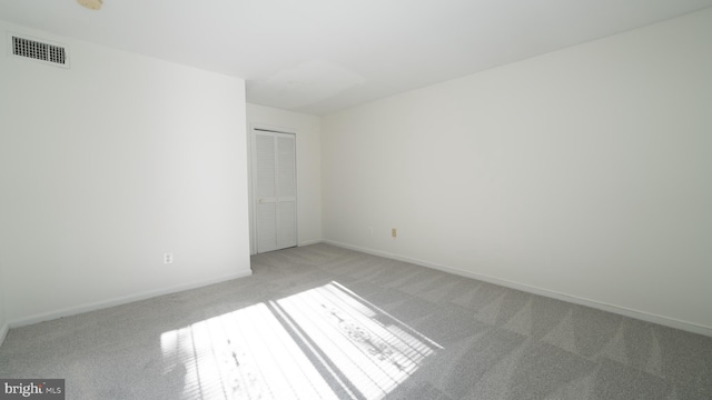 unfurnished bedroom with light carpet and a closet