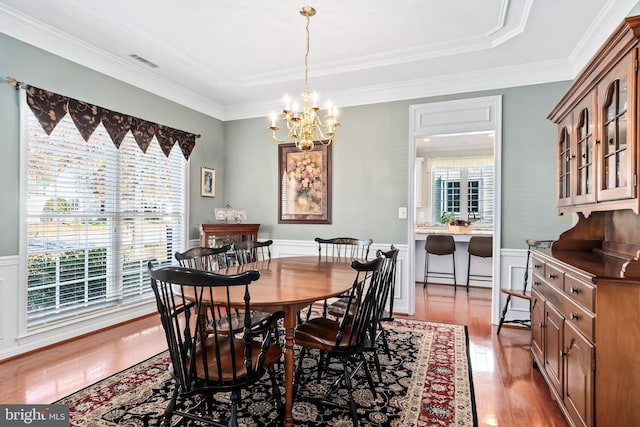 dining space with a chandelier, a wealth of natural light, light hardwood / wood-style floors, and crown molding