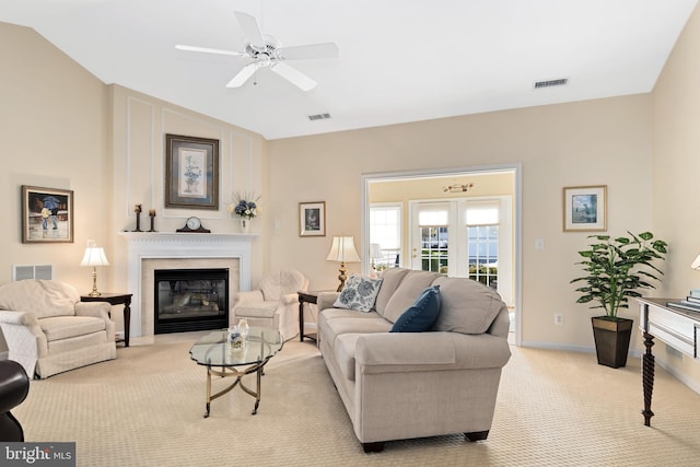 living room with a premium fireplace, lofted ceiling, light carpet, and ceiling fan