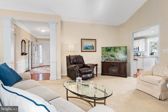 carpeted living room with decorative columns