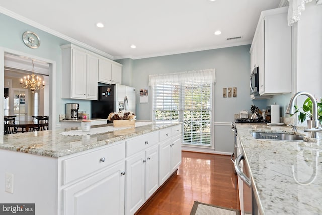 kitchen featuring crown molding, appliances with stainless steel finishes, sink, white cabinets, and dark wood-type flooring