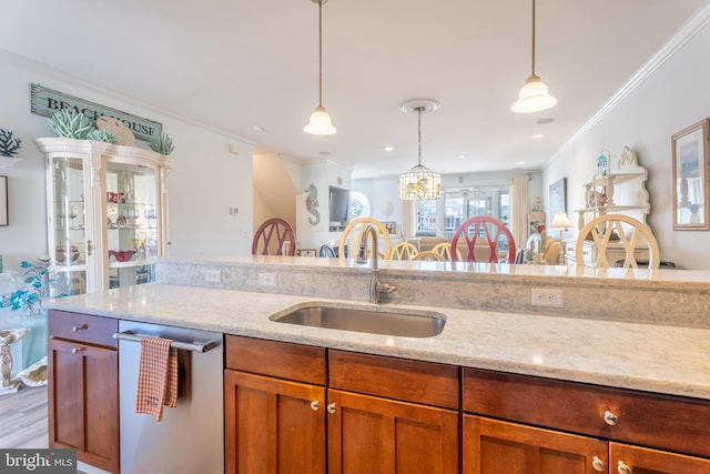 kitchen featuring ornamental molding, sink, pendant lighting, light wood-type flooring, and stainless steel dishwasher