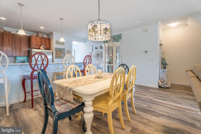 dining room featuring crown molding, light hardwood / wood-style flooring, and a notable chandelier