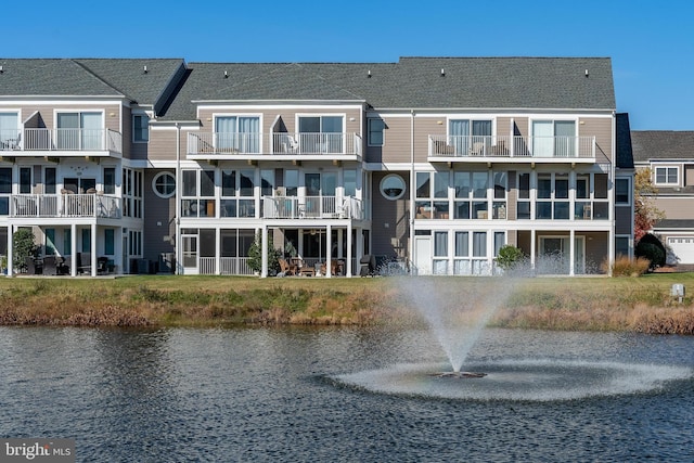 rear view of house featuring a balcony, cooling unit, and a water view