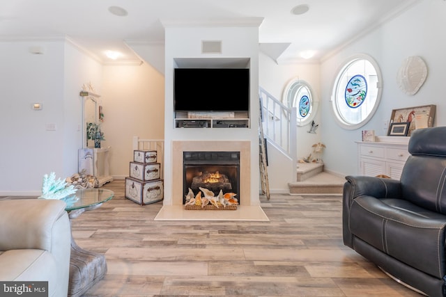 living room with ornamental molding and light wood-type flooring