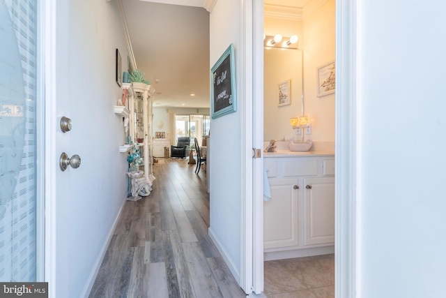 corridor featuring ornamental molding and light wood-type flooring