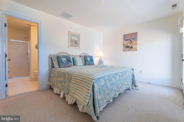 bedroom featuring connected bathroom and light colored carpet