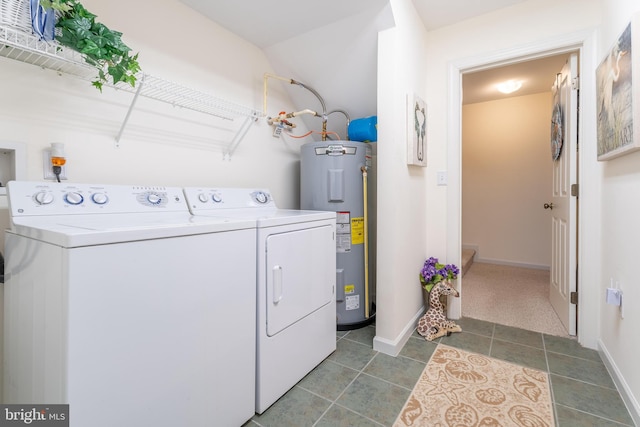 clothes washing area featuring water heater, independent washer and dryer, and tile patterned flooring