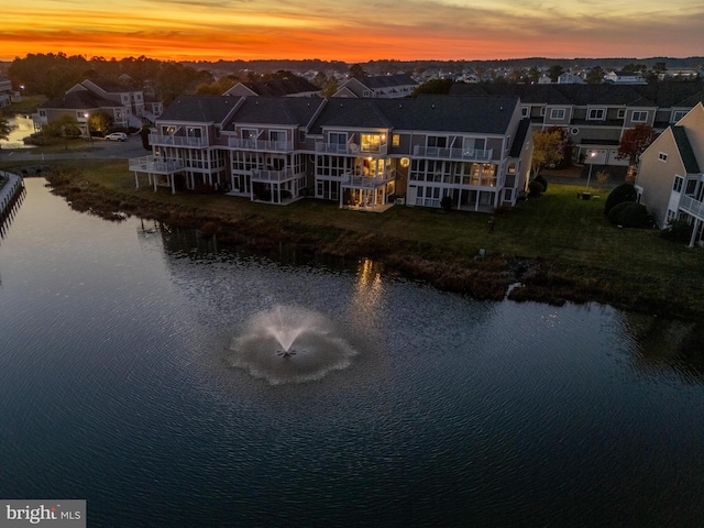 aerial view at dusk featuring a water view