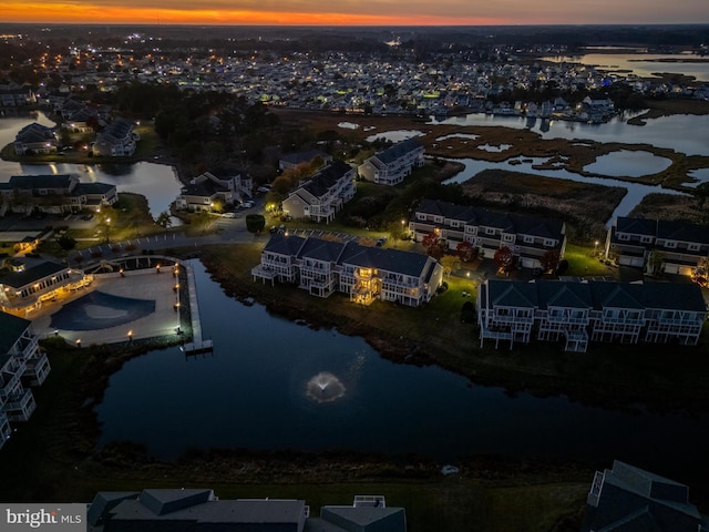 aerial view at dusk featuring a water view