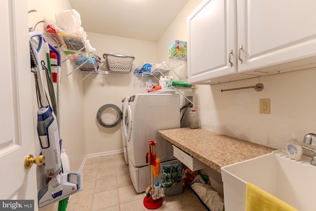 washroom featuring cabinets, washer and clothes dryer, and sink