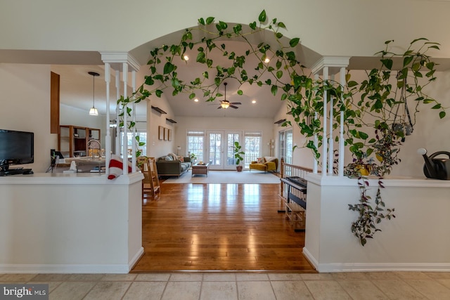 living room with french doors, lofted ceiling, decorative columns, ceiling fan, and light wood-type flooring