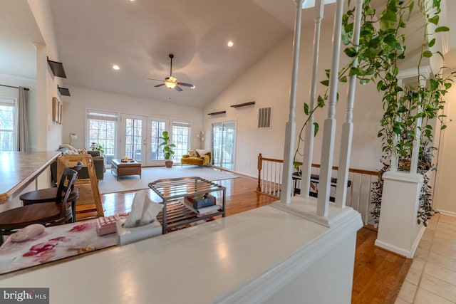 living room featuring a wealth of natural light, ceiling fan, high vaulted ceiling, and light hardwood / wood-style floors