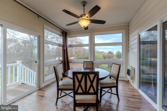 sunroom with heating unit, a wealth of natural light, and ceiling fan