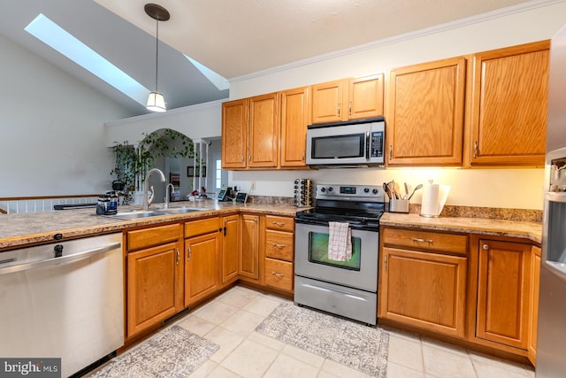 kitchen with sink, ornamental molding, vaulted ceiling with skylight, pendant lighting, and appliances with stainless steel finishes