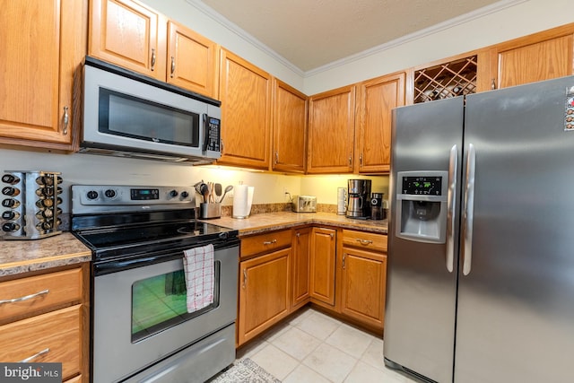 kitchen with appliances with stainless steel finishes, a textured ceiling, and ornamental molding