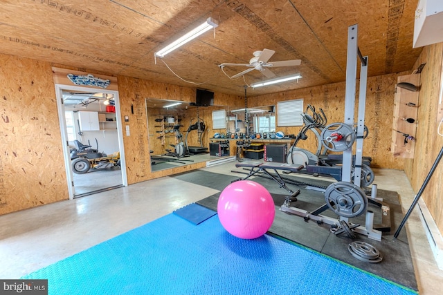 exercise room with concrete flooring, plenty of natural light, ceiling fan, and a workshop area