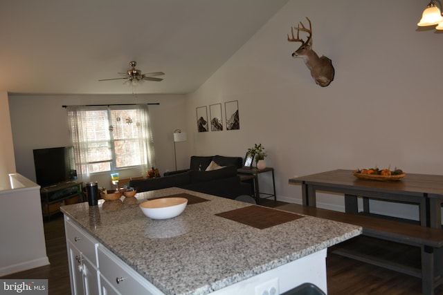 kitchen featuring dark hardwood / wood-style floors, vaulted ceiling, a center island, white cabinets, and ceiling fan