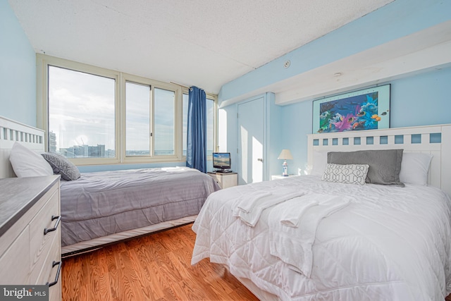 bedroom with a textured ceiling and light hardwood / wood-style floors