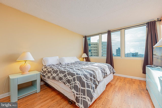 bedroom with a textured ceiling and hardwood / wood-style flooring