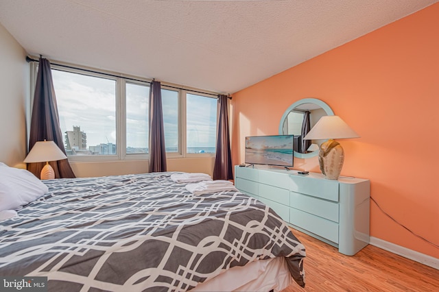 bedroom with a textured ceiling and light wood-type flooring