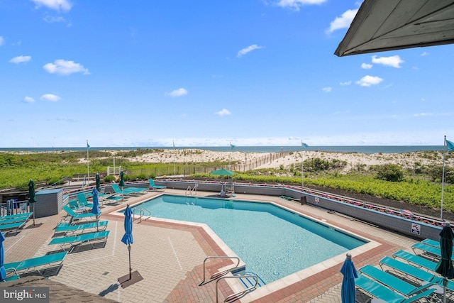 view of swimming pool with a water view and a patio area