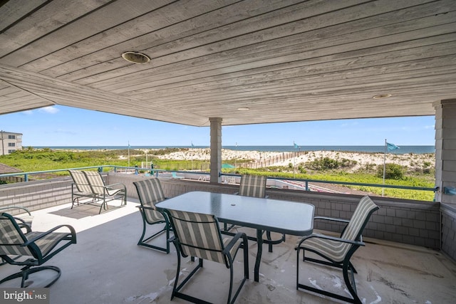 view of patio / terrace with a beach view and a water view