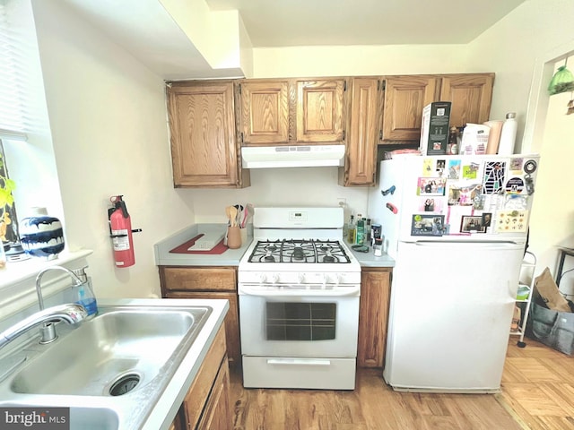 kitchen with white appliances, light hardwood / wood-style flooring, and sink