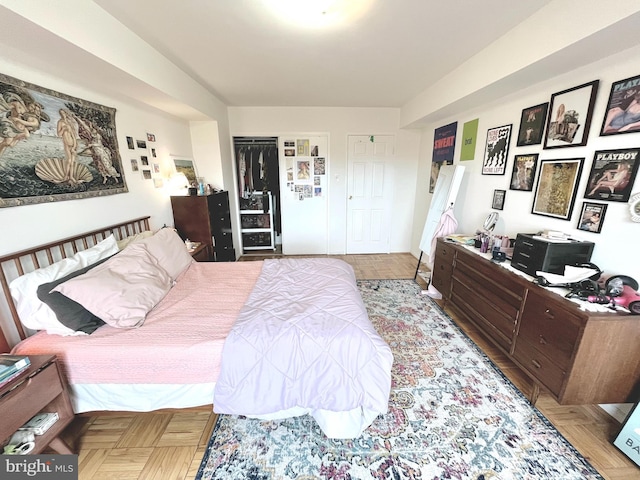 bedroom with light parquet flooring and a closet