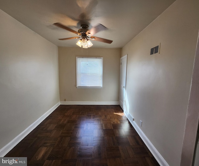 unfurnished room with dark parquet flooring and ceiling fan