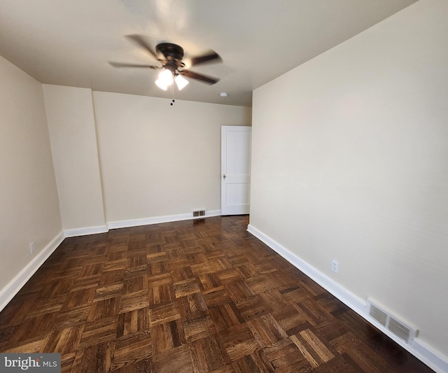 empty room with dark parquet flooring and ceiling fan