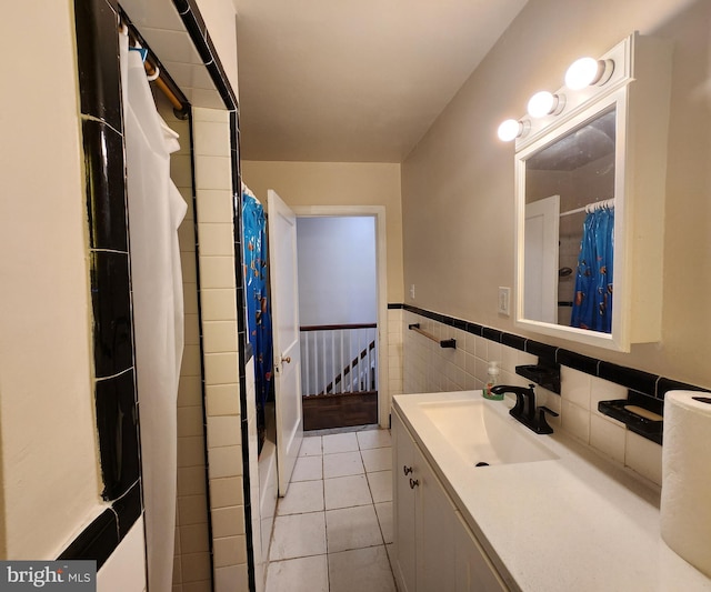 bathroom featuring a shower with shower curtain, vanity, tile patterned floors, and tile walls