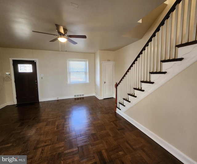 foyer with dark parquet floors and ceiling fan