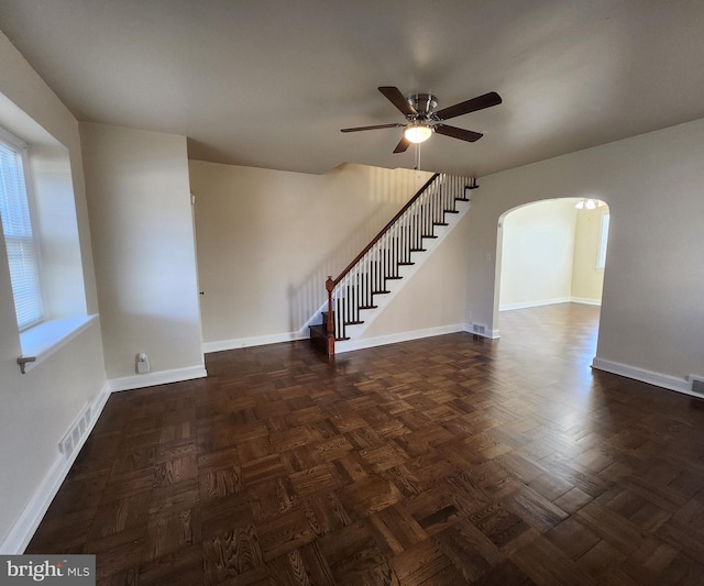 unfurnished room with ceiling fan and dark parquet floors