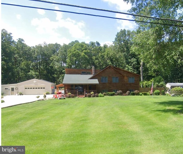 view of front of home featuring a front lawn, a garage, and an outdoor structure