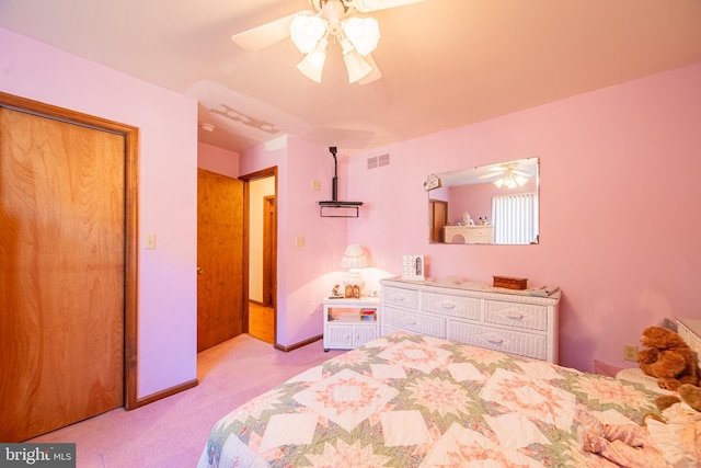 bedroom with light carpet, ceiling fan, and a closet