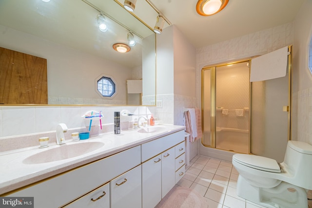 bathroom with toilet, tile walls, tile patterned flooring, an enclosed shower, and vanity