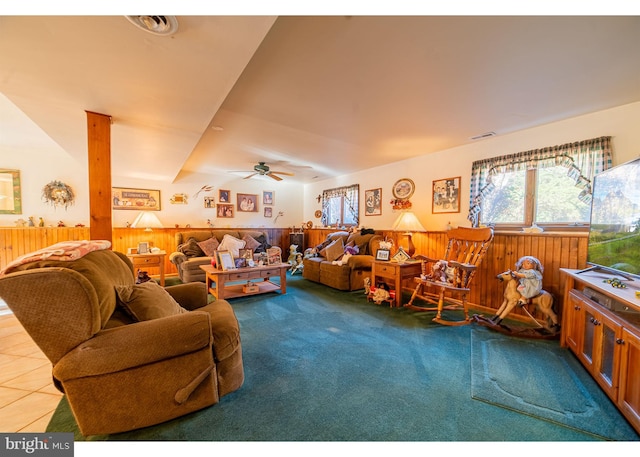 living room featuring carpet, wood walls, and ceiling fan