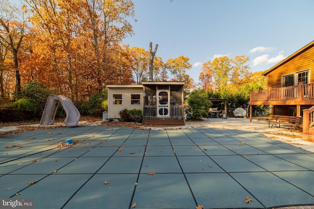 view of pool with a patio area, a water slide, and a deck