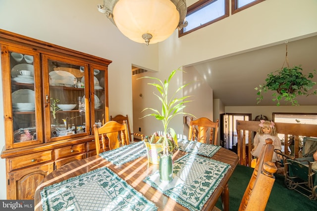 dining room with high vaulted ceiling