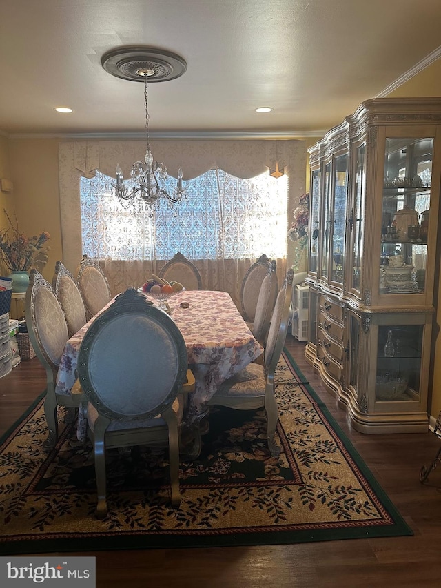 dining space with crown molding, dark wood-type flooring, and a chandelier