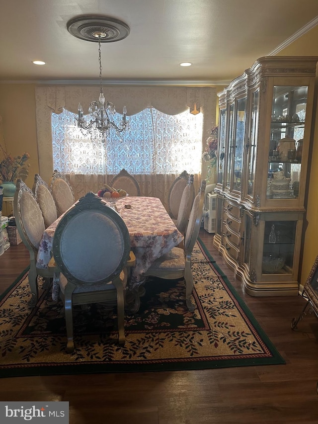 dining area with a notable chandelier, dark hardwood / wood-style floors, and ornamental molding